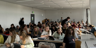 Der Seminarraum ist gefüllt mit vielen Studierenden.